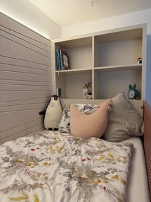 Útulná dětská ložnice s postelí, policemi a hračkami.